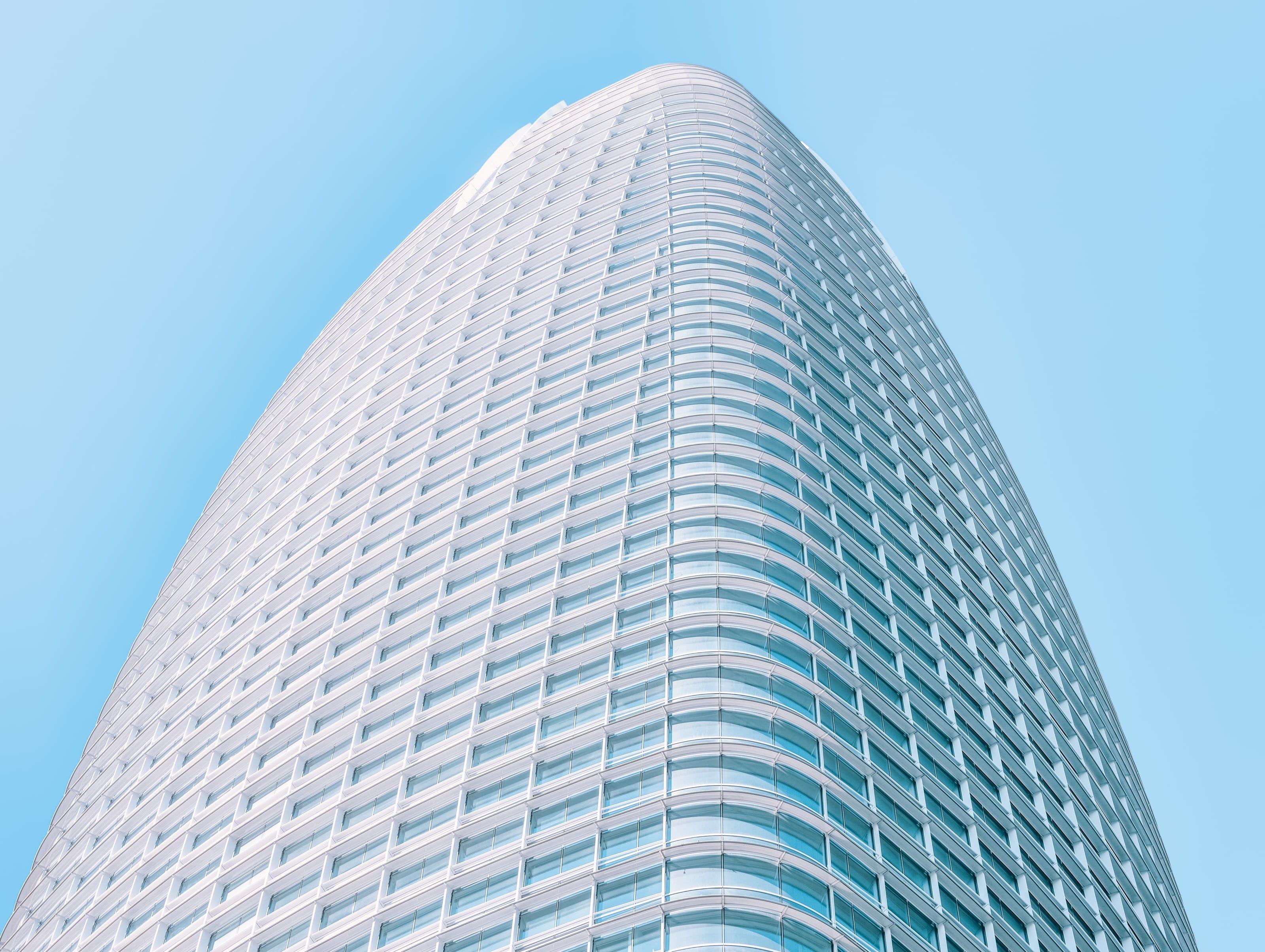 Salesforce Tower's tapering white façade against a clear blue sky